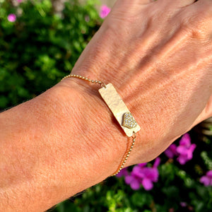 14k yellow gold LIZZ bracelet with diamond heart on model wrist