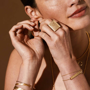 14k gold NEVO bar wrap bracelet with 6 diamonds and diamond dangle on model with No.1 block ring