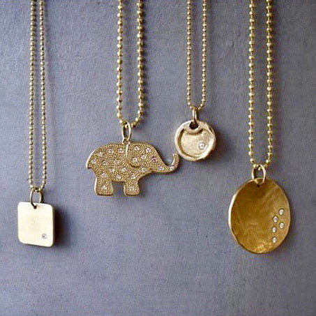 14k yellow gold medium ELLI elephant charm with scattered diamonds and sapphire eye hanging with MORA and DODD