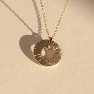 14k gold GORB circle etched charm in studio